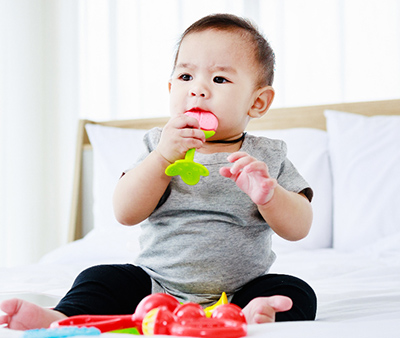 development in baby concept. pretty baby play baby toy on bed.
